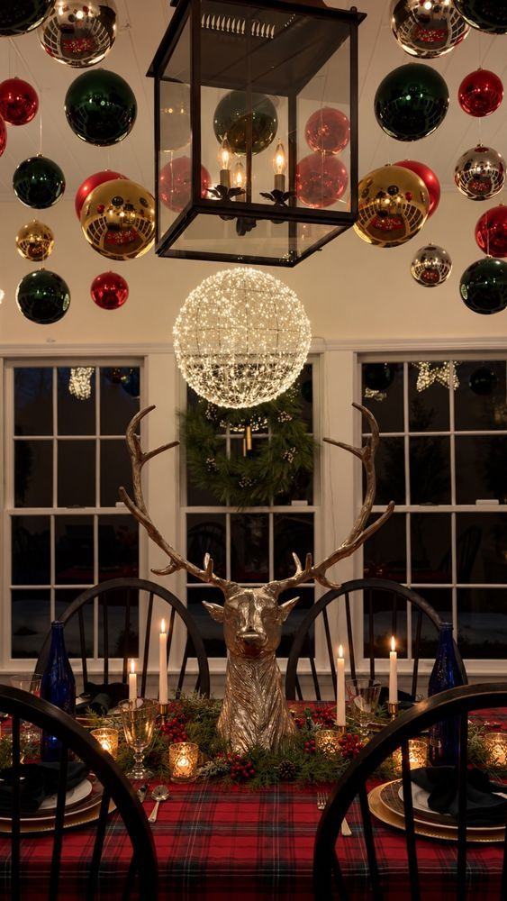 A tartan table beneath hanging ornaments with a brass reindeer centerpiece