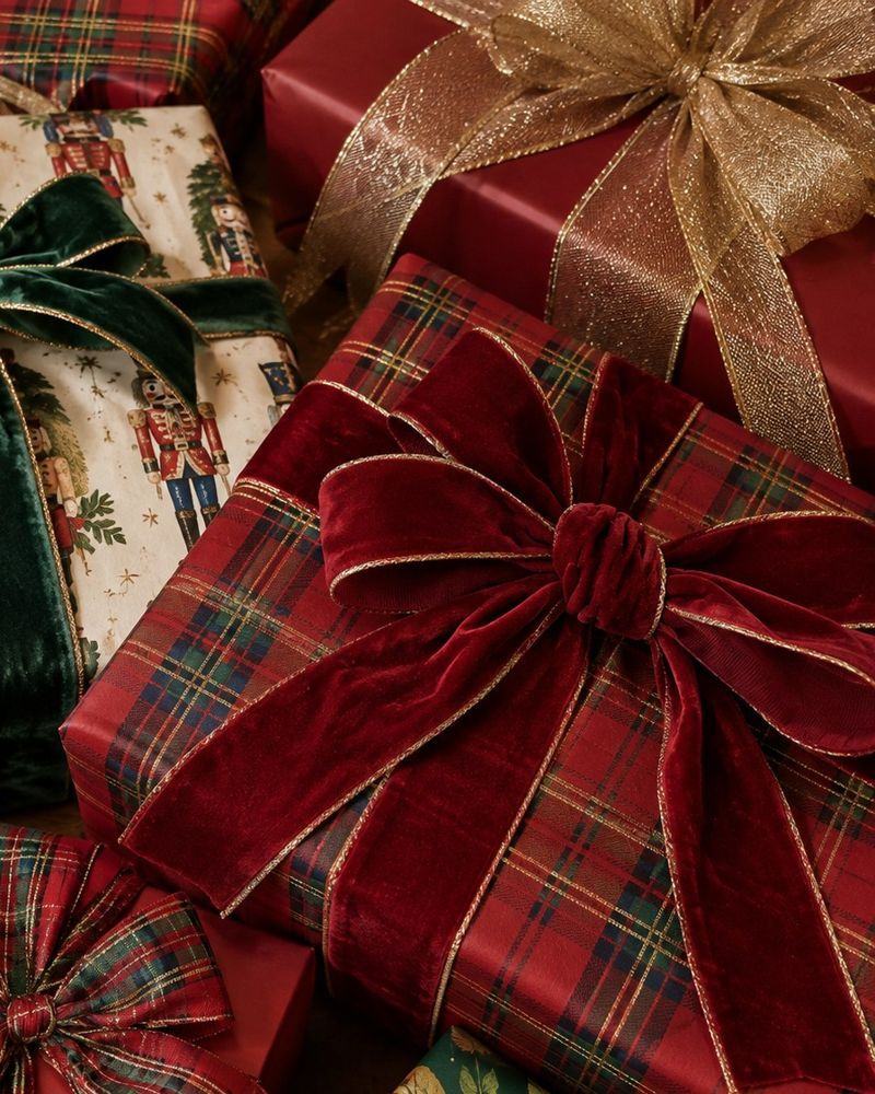 Gifts wrapped in tartan with a red velvet bow and gold ribbon