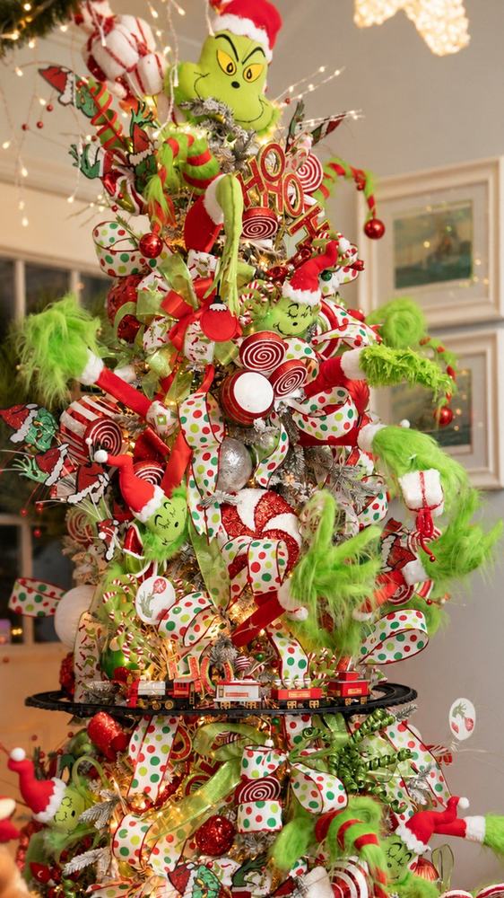 A whimsical tree with plush characters, polka-dot ribbon, peppermints and a toy train
